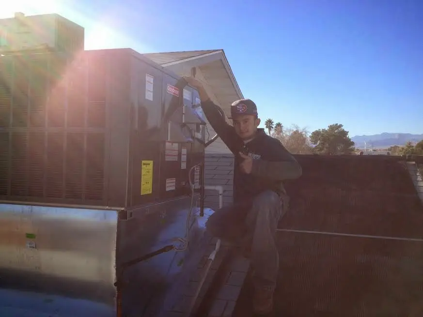 HVAC technician performing AC Tune-Up on a rooftop unit in Sparta